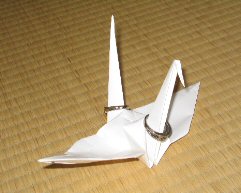 Origami crane, bearing the wedding rings